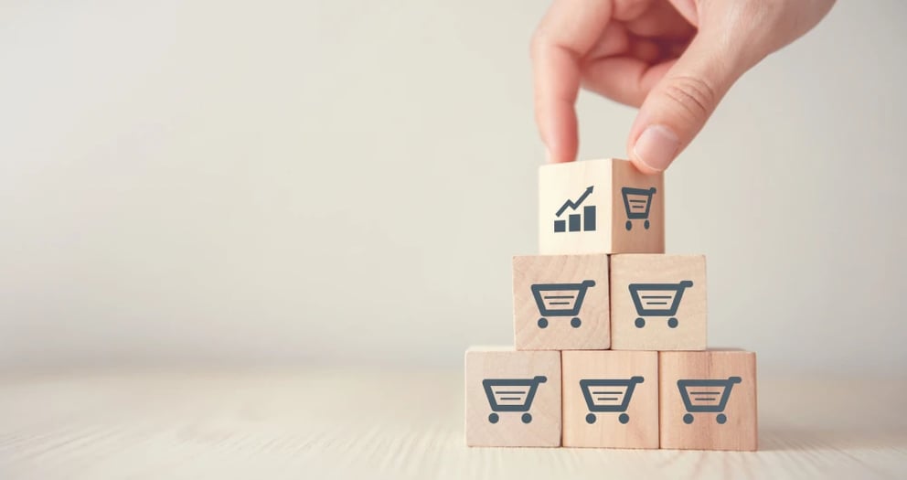 Small wooden blocks stacked on top of each other, with shopping carts on each of the blocks