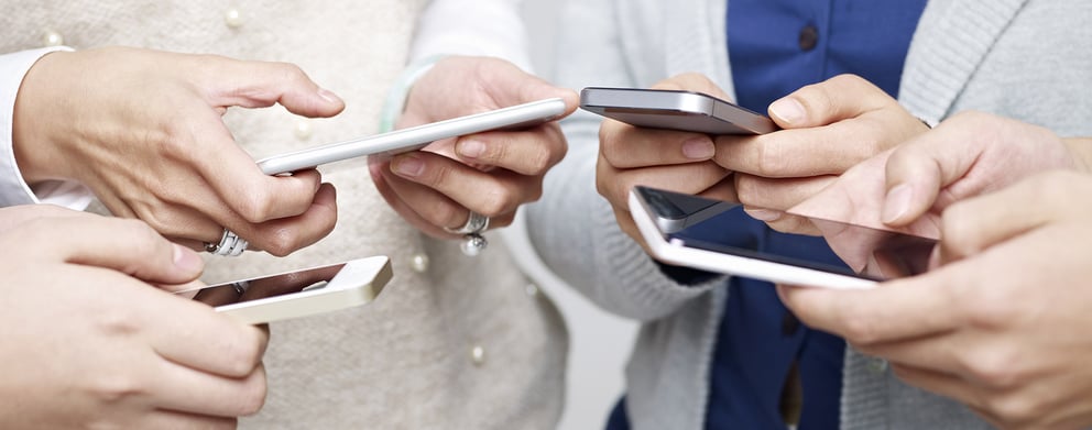 A group of people using their phones together.