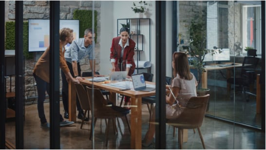 four people discussing around a table, in a room