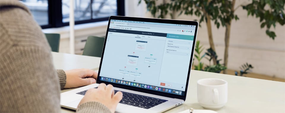 A man using the Hubspot Workflow tool on his laptop